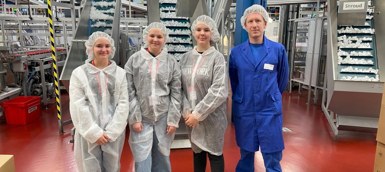 Drei Schülerinnen absolvieren den Girls Day 2024 bei Zeller Plastik und Zeller Engineering in Zell, sind in Schutzkleidung gekleidet und schauen in die Kamera.