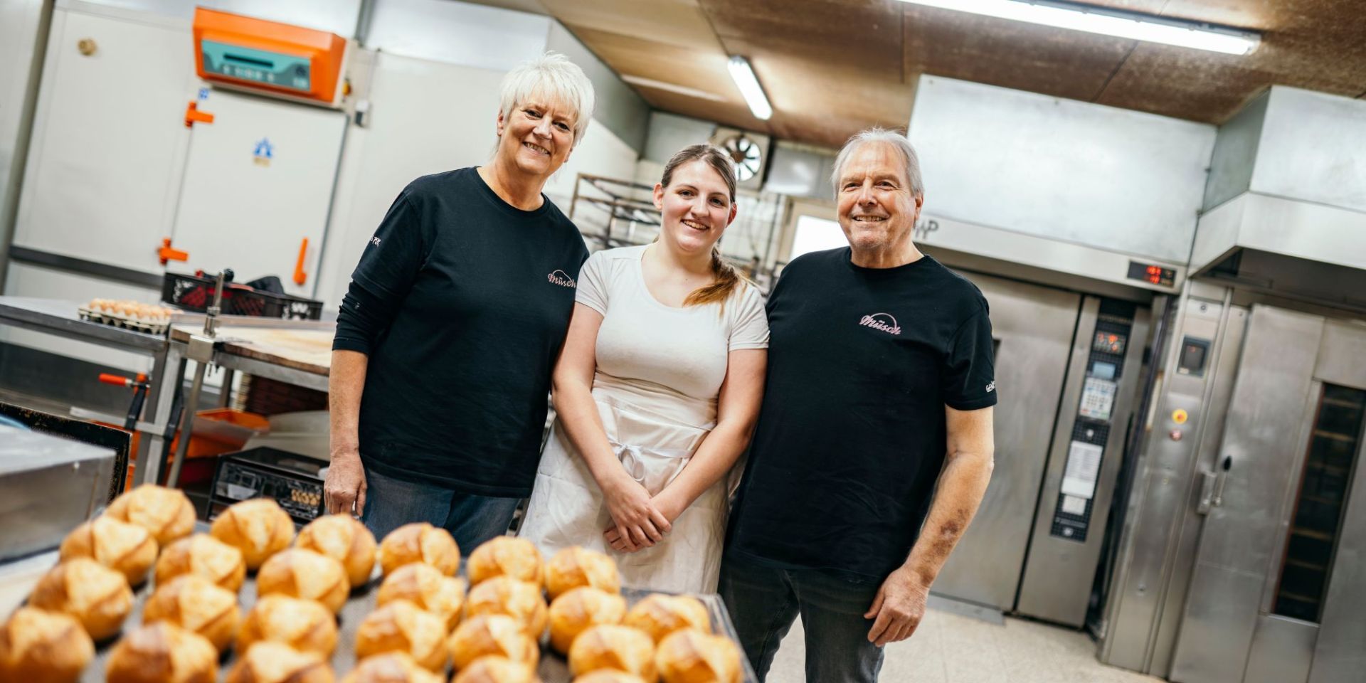 In der Backstube Familie Müsch und deren ehemalige Azubine stehen in der Produktionsstätte.