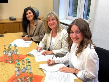 Melika Zare und Anna-Sophie Reffelmann bei der Vertragsunterzeichnung mit Anke Beilstein.
