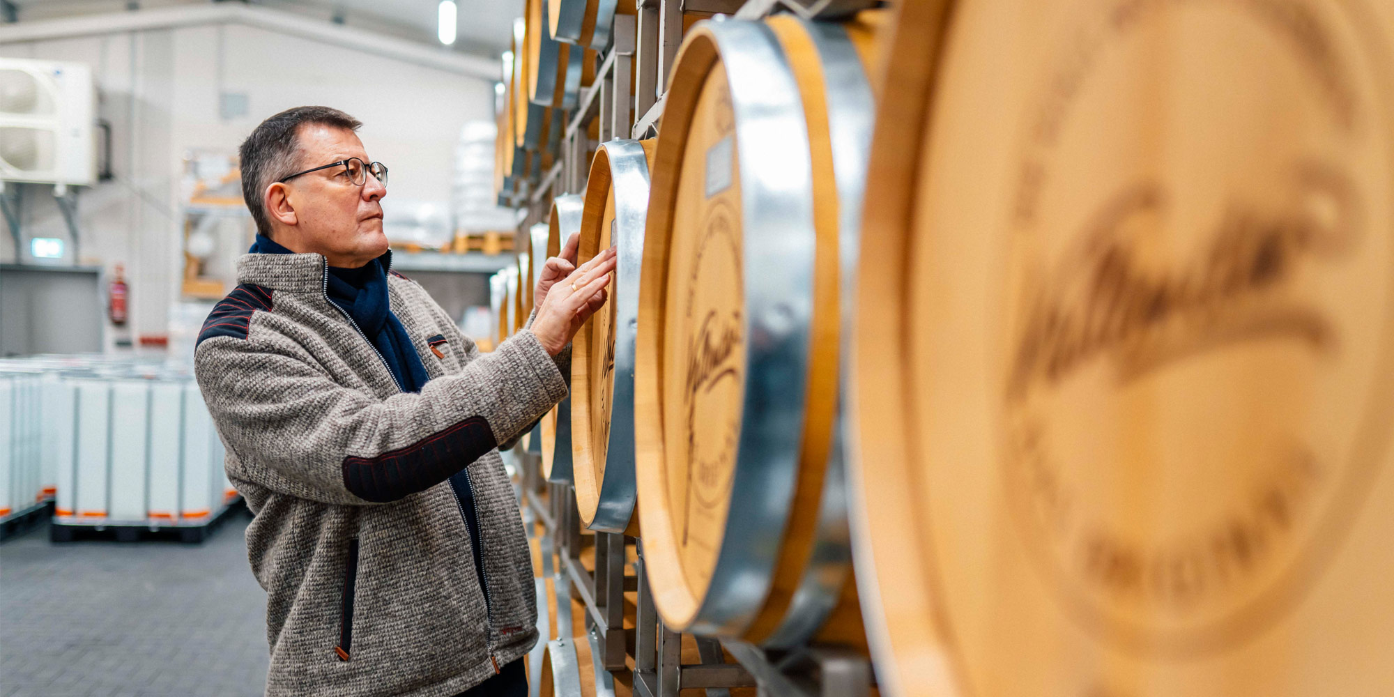 Hubertus Vallendar steht an Holzfässern in seiner Brennerei in Kail.