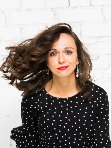 Anna Piechotta lächeln in die Kamera, ihre Haare wehen zur Seite.