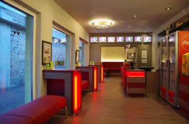 Das Bild zeigt den Eingangsbereich mit Theke und Sitzgelegenheiten des Apollo Kino in Cochem.