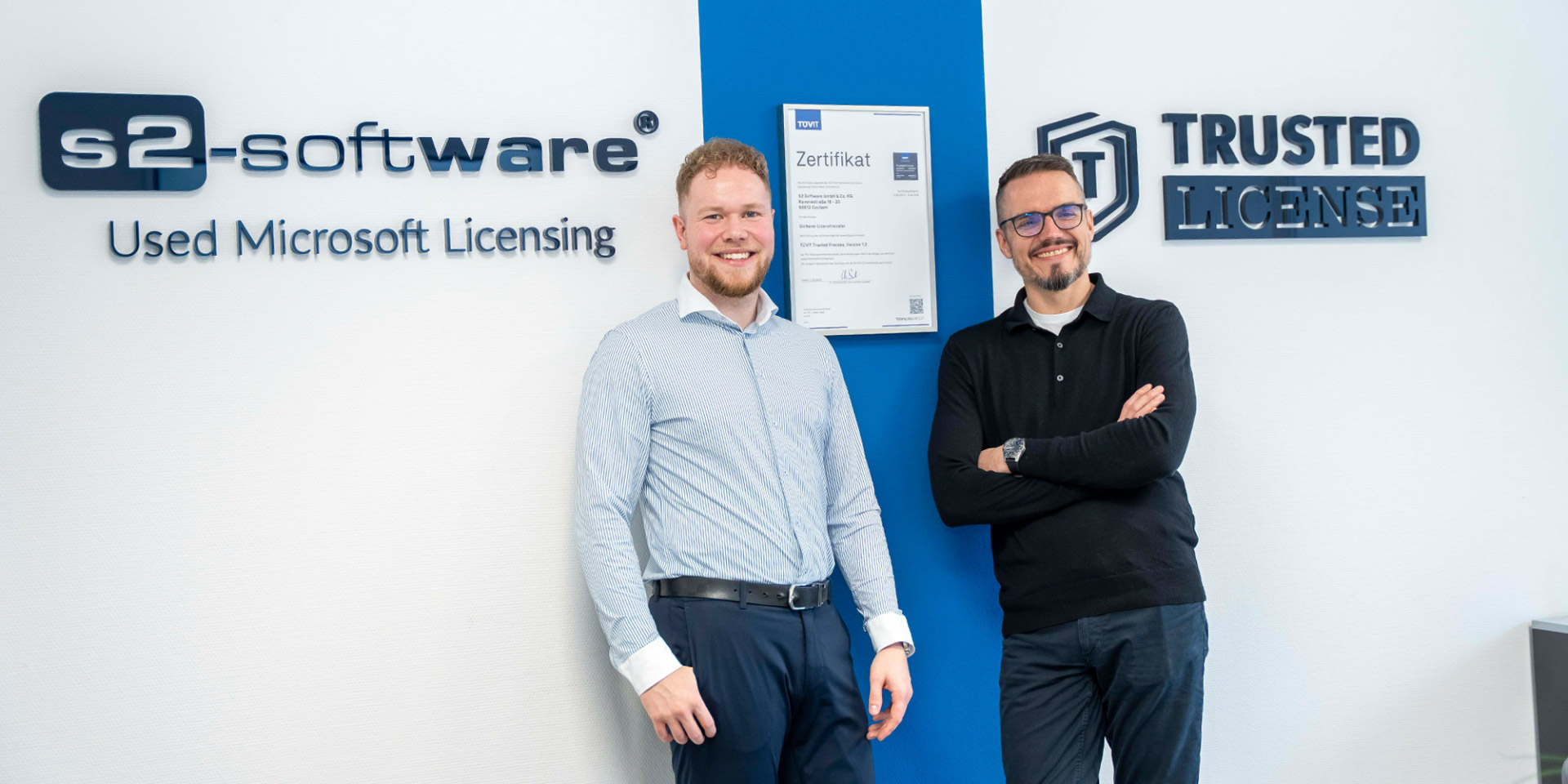 Roland Schausten und René Hergenröther Roland Schausten und René Hergenröther vor der Wand mit Logo von S2-Software
