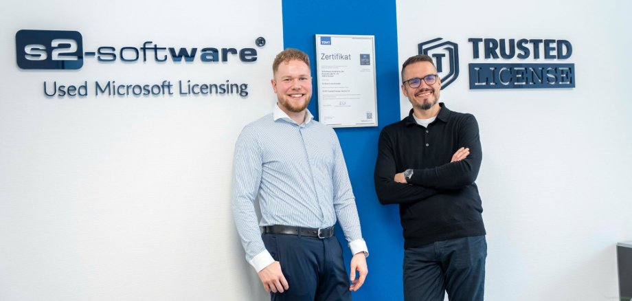 Roland Schausten und René Hergenröther vor der Wand mit Logo von S2-Software