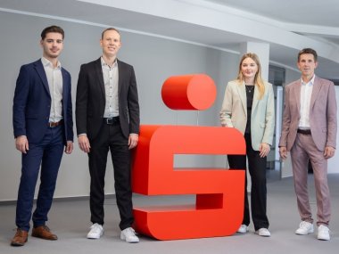 Gruppenbild in der Sparkasse mit Azubi Admir, Geschäftsstellenleiter Jan Eric Schütze, Auszubildende Mina und Regionalleiter Frank Michels (von links nach rechts).