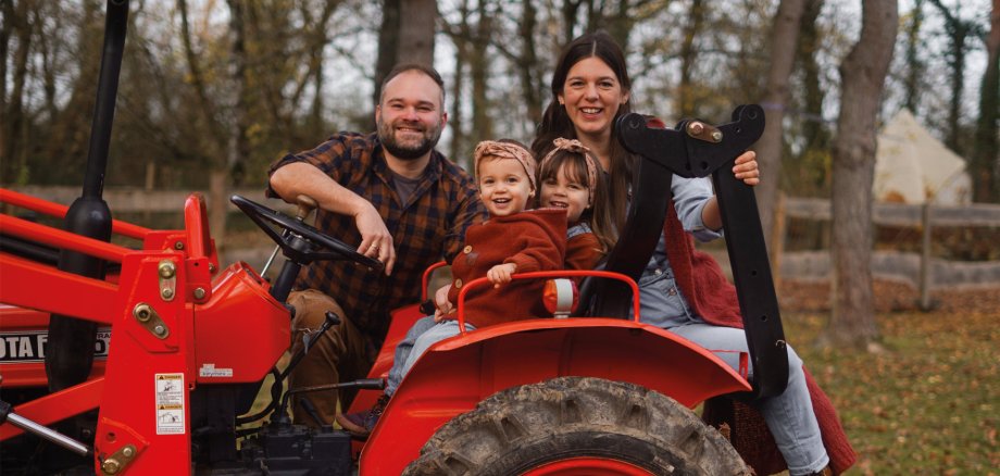 Carmen und Mätty mit Familie auf dem Traktor Familienfoto von Carmen und Mätty (Naturerlebnishof Vulkaneifel) auf einem Traktor