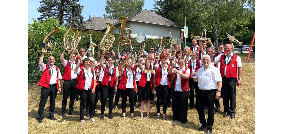 Gruppenfoto der Kirchspielmusikanten, die ihre Instrumente in die Höhe strecken