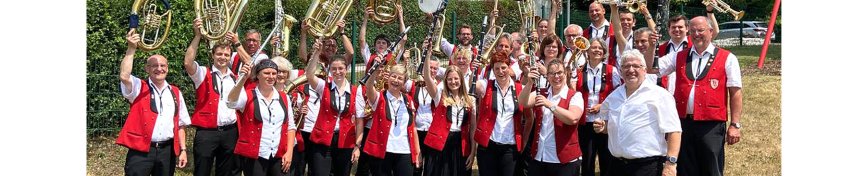 Kirchspielmusikanten - Titelbild Gruppenfoto der Kirchspielmusikanten, die ihre Instrumente in die Höhe strecken