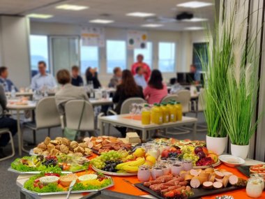 Unternehmerfrühstück - Frühstück im Vordergrund, Teilnehmer im Hintergrund