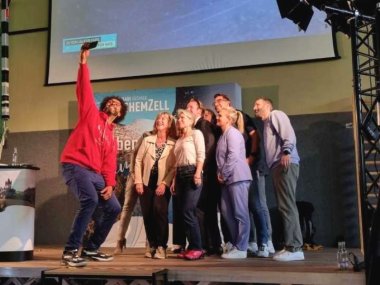 Redner, Organisatoren und, Sponsoren versammeln sich zum Abschluss auf der Bühne und machen ein Selfie.