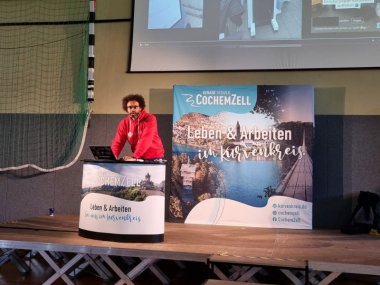 Bär auf der Bühne, auf der Leinwand hinter Bär laufen die Szenen des Hackingangriffs.