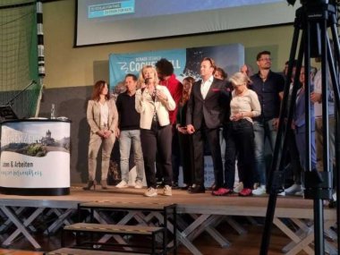 Viele Ehrengäste sameln sich auf der Bühne.