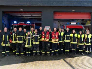 Die Mitglieder der Feuerwehr Karden stehen in Feuerwehrkleidung zusammen und schauen in die kamera.