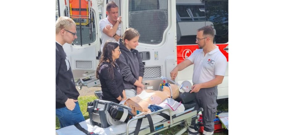 Erste Hilfe Workshop Das DRK zeigt am Krankenwagen, wie man richtig reanimiert und Erste Hilfe leistet.