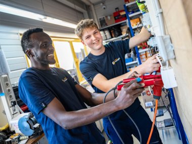 Zwei Mitarbeiter von Elektro Konrath haben Spaß bei der Arbeit.