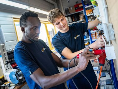 Zwei Mitarbeiter von Elektro Konrath bei der Arbeit an einem Schaltkasten.