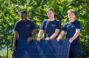 Mitarbeiter von Elektro Konrath mit einem Solarpanel bei Sonnenschein.