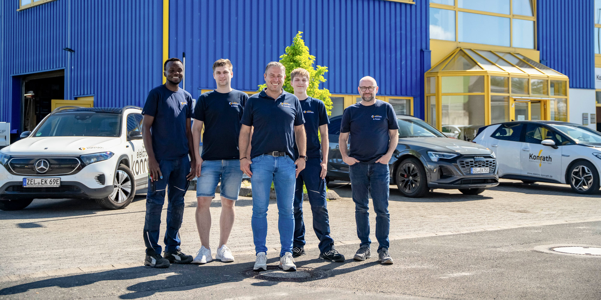 Titelbild Elektro Konrath Das Team von Elektro Konrath vor dem blauen Firmengebäude.