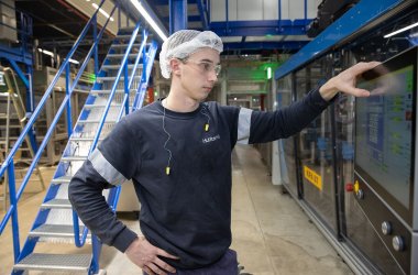 Huhtamaki Mitarbeiter Rene Dahmen an Maschine