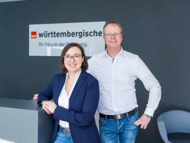 Susanne und Sascha Johann vor dem Logo der Württembergischen Versicherung