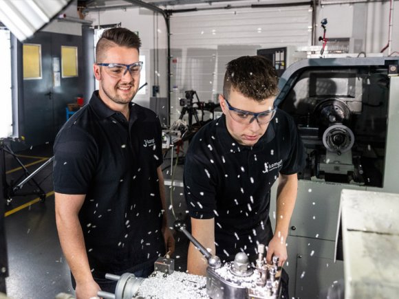 Ausbilder und Azubi bei Kampf Ein Azubi mit seinem Ausbilder bei der Arbeit an einer Drehmaschine bei Kampf