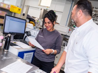 Zwei Mitarbeiter unterhalten sich in der Produktionsabteilung