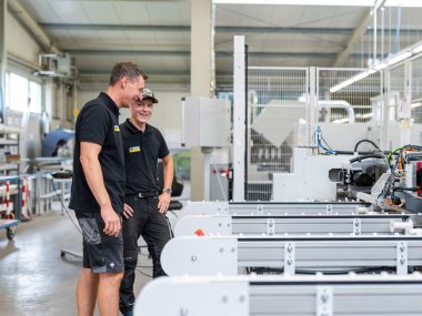 Die Mitarbeiter Marvin und Andre vor einer Maschine