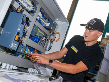 Azubi Marvin verkabelt eine Produktionsanlage
