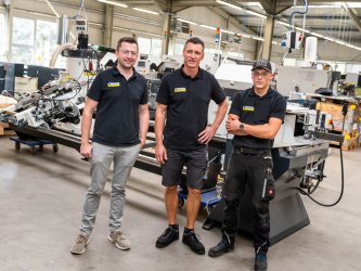 Gruppenfoto Jan, Andre und Marvin Jan, Andre und Marvin stehen vor einer Maschine bei der Firma Pressta-Eisele
