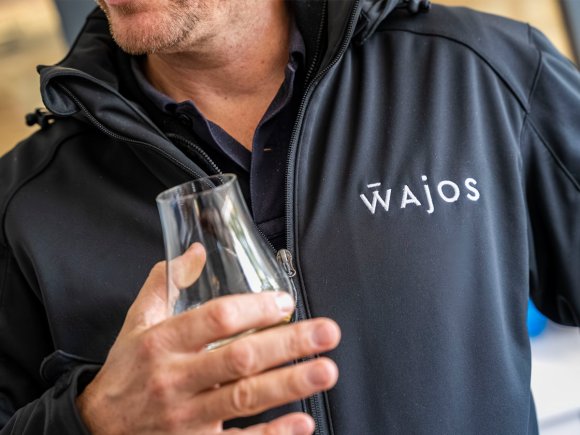 Nahaufnahme von Glas und Wajos-Pullover Nahaufnahme eines Probierglases und eines Pullovers mit Wajos-Logo