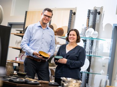 Peter Wirtz und eine Mitarbeiterin halten Produkte der Firma in der Hand