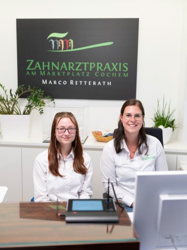 Zwei Mitarbeiterinnen der Zahnarztpraxis Retterath im Empfangsbereich.