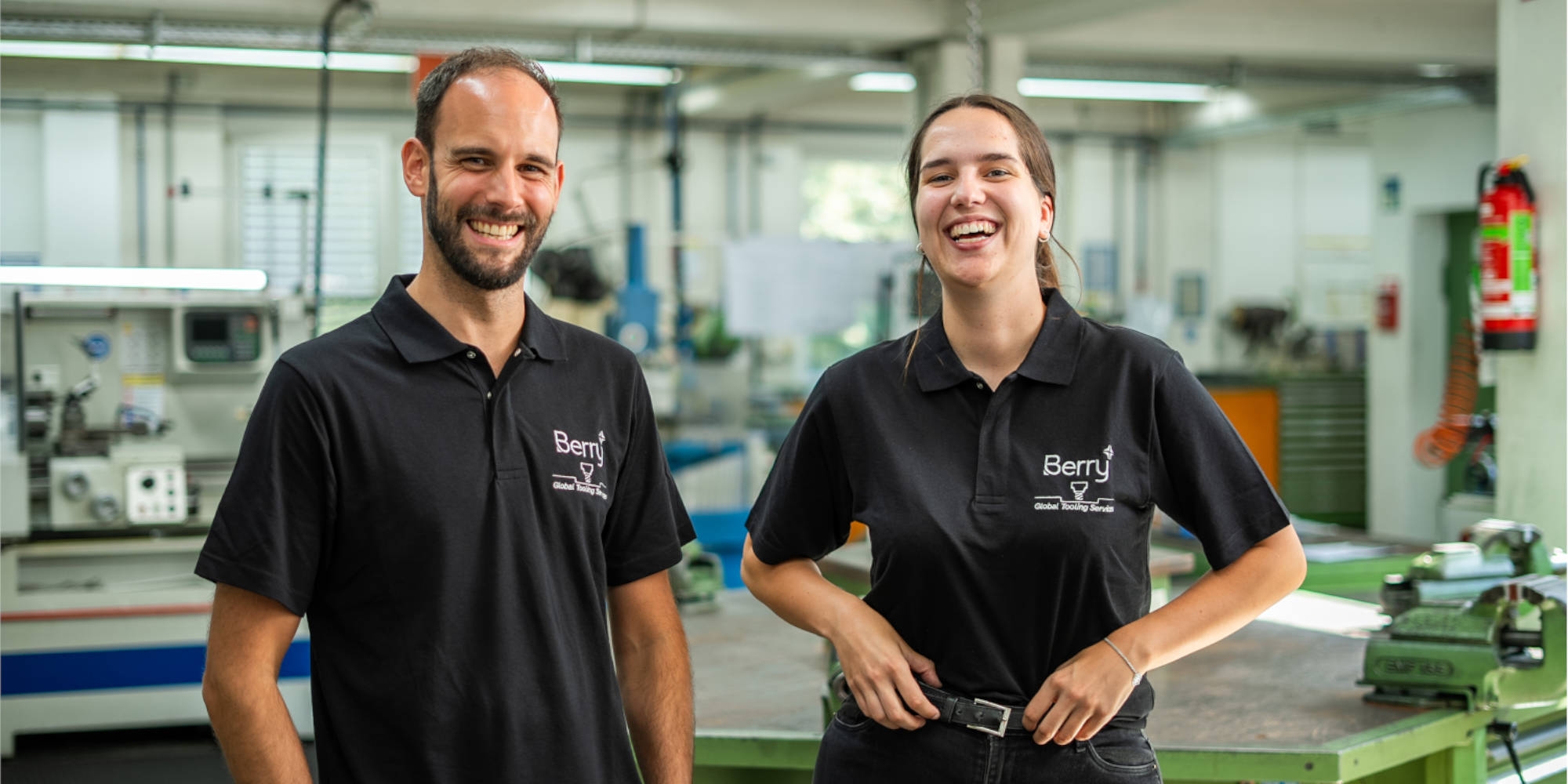 Auszubildende mit ihrem Ausbilder Auszubildende Annika und Ausbilder Christian stehen nebeneinander und lachen in die Kamera