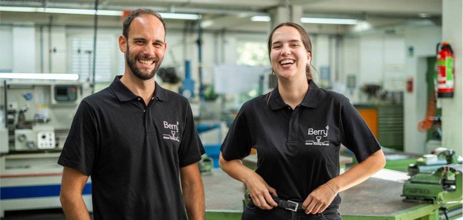 Auszubildende Annika und Ausbilder Christian stehen nebeneinander und lachen in die Kamera