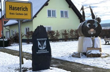 Das Ortsschild der Gemeinde Haserich im Hunsrück mit Hasenfigur am Ortseingang
